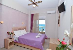 利迈纳里亚阿加利酒店的一间带紫色床的卧室和一个阳台
