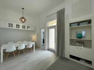 特罗亚Beautiful Penthouse Apartment With Terrace - 4 Minute Walk to the Beach的厨房以及带白色桌椅的用餐室。