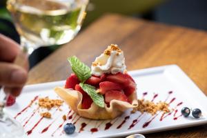 丰特奈勒孔特Logis Hôtel-Restaurant LE FONTARABIE的盘子里的甜品,包括草莓和奶油