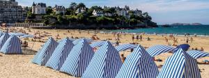 迪纳尔Studio centre Dinard的海滩上一群蓝白条纹的遮阳伞