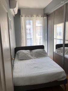 尼斯盎格鲁大道29号公寓的一间卧室设有一张床和两个窗户。