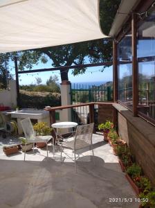 因佩里亚La Quercia Agriturismo的庭院设有桌椅,享有美景。