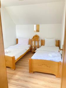 扎布利亚克Guest House Nena的配有白色墙壁和木地板的客房内的两张床
