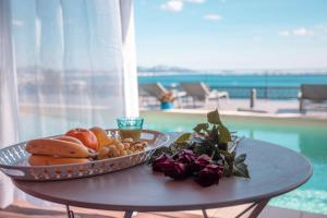 马赛LES SUITES LOVE 1 SPA VUE MER PISCINe的游泳池畔桌子上放着水果和蔬菜的托盘