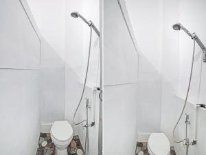 棉兰OYO 90387 Sepakat Guest House的一间带两个卫生间和淋浴间的浴室