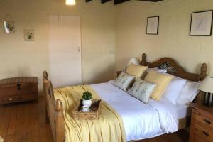 ArboeClannad Cottage的卧室配有一张带白色床单和枕头的大床。