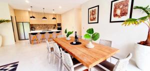 NgatangiiaMama Taras Luxury Villa的厨房以及带木桌和椅子的用餐室。