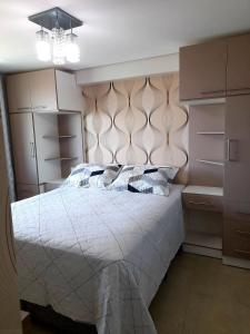 纳塔尔Ponta Negra RN01的卧室配有白色的床和吊灯。