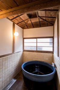 叶山町平野邸 Hayama的窗户客房内的大蓝色浴缸