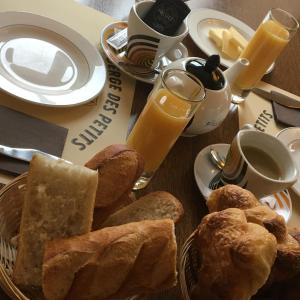 Saint-Igny-de-VersAuberge Des Petits的桌子上放着一盘面包和橙汁