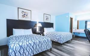 WellingtonSky-Palace Inn & Suites Wellington的酒店客房设有两张床和盥洗盆