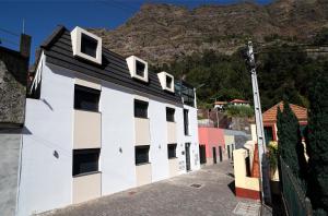 库拉尔-达斯弗雷拉斯Coração da Madeira的一座白黑的建筑,背景是一座山