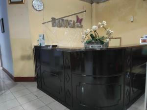 马卡萨OYO 90529 Hotel Baruga Makassar的黑色的柜台,上面有花瓶