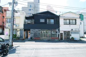 热海Atelier & Hostel Nagaisa-Ura的街道拐角处的黑色建筑