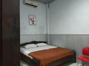 马卡萨OYO 90529 Hotel Baruga Makassar的一张小床,位于一个红色椅子的房间