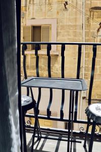 科斯皮夸The Mike Hotel by CX Collection的一张黑色长凳,坐在阳台,配有两把椅子