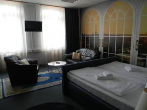 开姆尼茨Rothenberger的一间卧室配有一张床、一张沙发和一把椅子