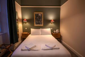 道格拉斯堡Douglas Arms Hotel的一间卧室配有一张床,上面有两条毛巾