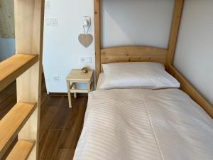 拉伊翁Alpine Chalet Aurora Dolomites的一间小卧室,配有一张床和一张边桌