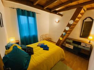 Saint-Roman-de-TousqueMaison LGBT des Monts Bleus的一间卧室配有一张黄色的床和蓝色窗帘
