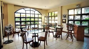 伊洛伊洛埃尔哈希恩德罗私人酒店的餐厅设有桌椅和窗户。