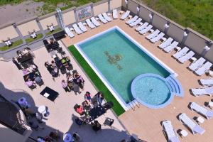 索非亚Hotel Dragalevtsi的游泳池的顶部景色,设有椅子和人