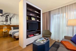 汉堡汉堡米歇尔馨乐庭服务公寓公寓式酒店的一间客厅,内设一张床和一台电视机