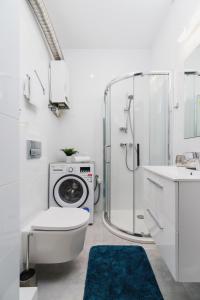 克拉科夫Apartment Smoluchowskiego Cracow by Renters的一间带卫生间、淋浴和洗衣机的浴室