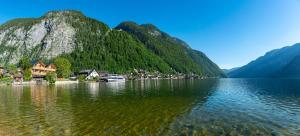 哈尔施塔特Boutiquehotel Strand Hallstatt - Adults only的一大片水体,背景是群山