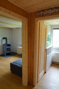 LangenbachRuhiges Ferienhaus am Waldrand mit Sauna und Kamin的一间设有门的客房,可通往带炉灶的房间