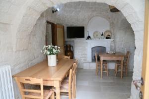 阿尔贝罗贝洛Trullo Montetrecarlini的一间厨房和带石墙的用餐室