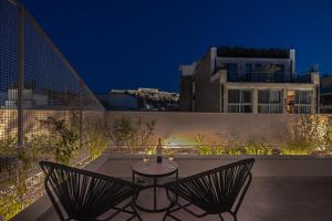 雅典Hellenic Vibes Smart Hotel的一个带两把椅子和一张桌子的庭院
