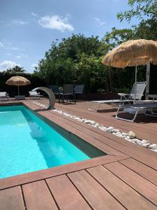 索托德拉马里纳Villa Playa San Juan的甲板上配有椅子和遮阳伞的游泳池