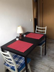 博特罗普Ferienwohnung A&K的一张黑色桌子,上面有两个红色的垫子