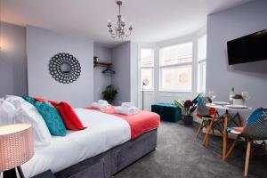 达宁顿堡Delven House, Apartment 2的一间卧室配有一张带色彩缤纷枕头的大床