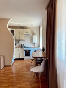 扎波罗热Apartment Sobornyi Prospect 95的厨房配有白色橱柜和桌椅