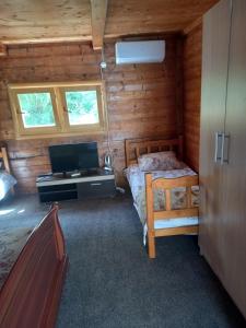 安吉Vikendica的小木屋内一间卧室,配有一张床和一张书桌