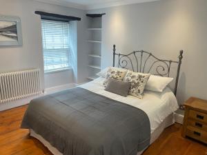 考布里奇17 Eastgate的卧室配有带枕头的床铺和窗户。