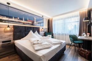 安达赫治Hotel Demas München-Unterhaching的酒店客房设有一张大床和一张书桌。
