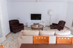 埃尔切Teniente Ruiz 27的客厅配有沙发、两把椅子和电视