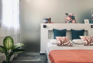 卡斯泰拉马莱Calida B&B的一间卧室配有带枕头和植物的床