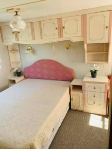 姆尔斯拉格斯Brīvdienu treileris的一间带大床和橱柜的小卧室