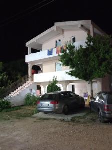 安吉MD Apartmani Canj的夜间停在房子前面的汽车