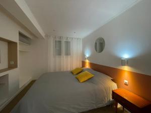圣洛Les sapins verts -inspiration deluxe的一间卧室配有一张带两个黄色枕头的床