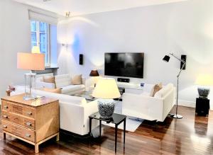 华沙MONDRIAN Luxury Suites & Apartments Old Town的客厅配有白色家具和平面电视