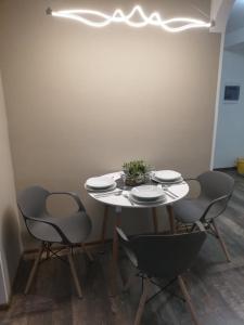 雷德尼斯Apartmány Rosijo的一张带四把椅子和盘子的白色桌子