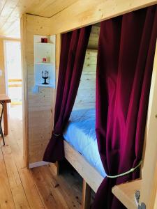 Saint-Genest-de-BauzonROULOTTE DE CHARME的木床间的床,带窗帘
