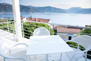克拉西奇Boka 2的俯瞰水面的阳台配有白色的桌椅