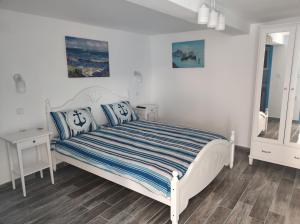 茹里洛夫卡Pensiune Blue Coral Jurilovca的一间卧室配有白色床和蓝色枕头