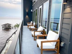 杰克逊维尔Upscale Condo Full Kitchen Balcony Rooftop Pool的坐在俯瞰大海的阳台上的一排椅子